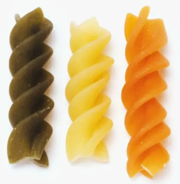 Three colorful fusilli pasta spirals in green, yellow, and orange representing sustainable, mindful cooking